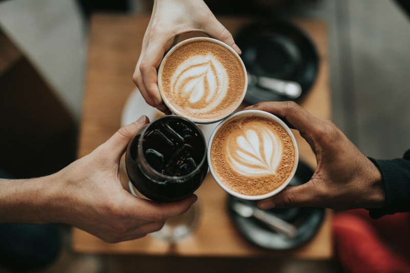 People holding coffee in cups together