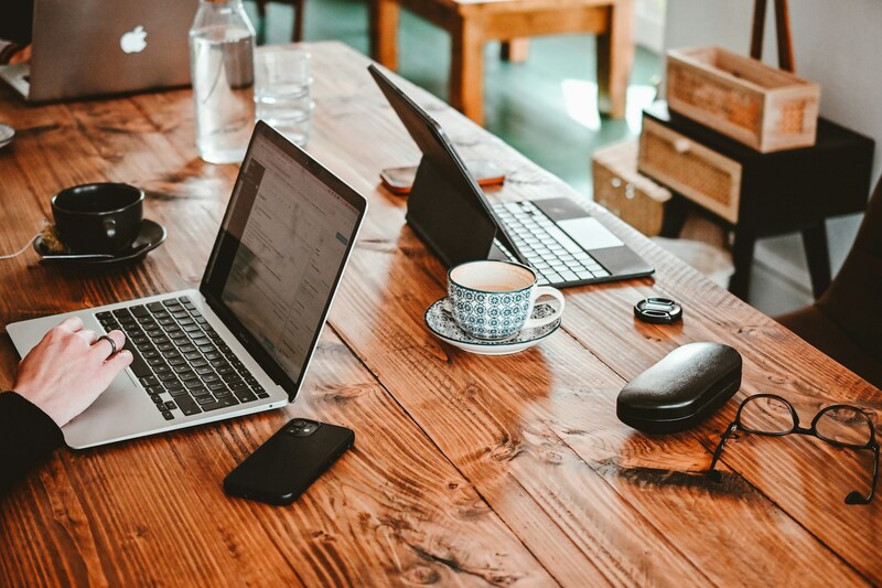 A person working on a laptop on a wooden table